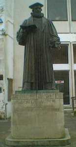 Statue of Archbishop Abbot in Guildford. Photo by SGBailey at en.wikipedia (Transferred from en.wikipedia) [GFDL (www.gnu.org/copyleft/fdl.html) or CC-BY-SA-3.0 (http://creativecommons.org/licenses/by-sa/3.0/)], from Wikimedia Commons